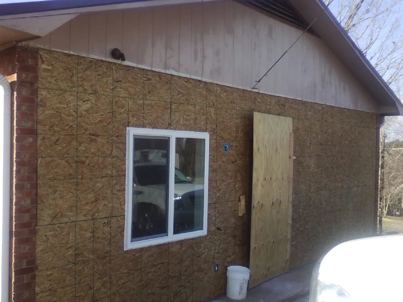 OSB sheathing on a garage addition wall before siding in Huntington